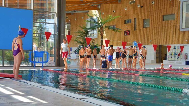 Des scolaires sont alignés au bord du bassin sportif de l'AquaGaron