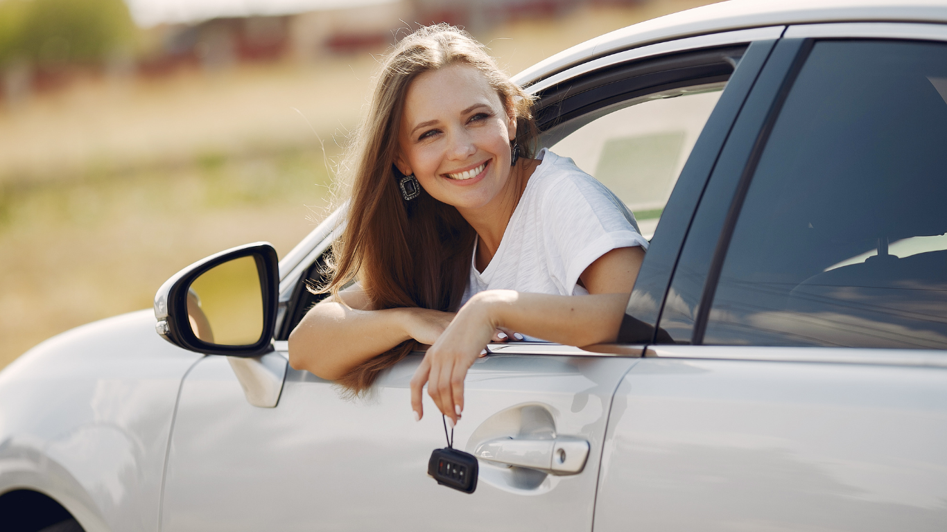 Photo d'une jeune femme accoudée à la portière de sa voiture